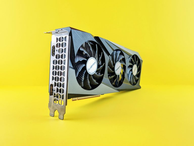 Close-up of a modern graphics card on a vibrant yellow background highlighting its design and technology.