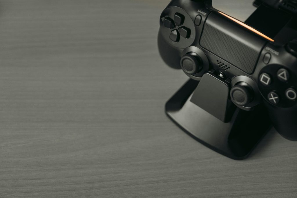 Black PS4 controller on display stand with copy space